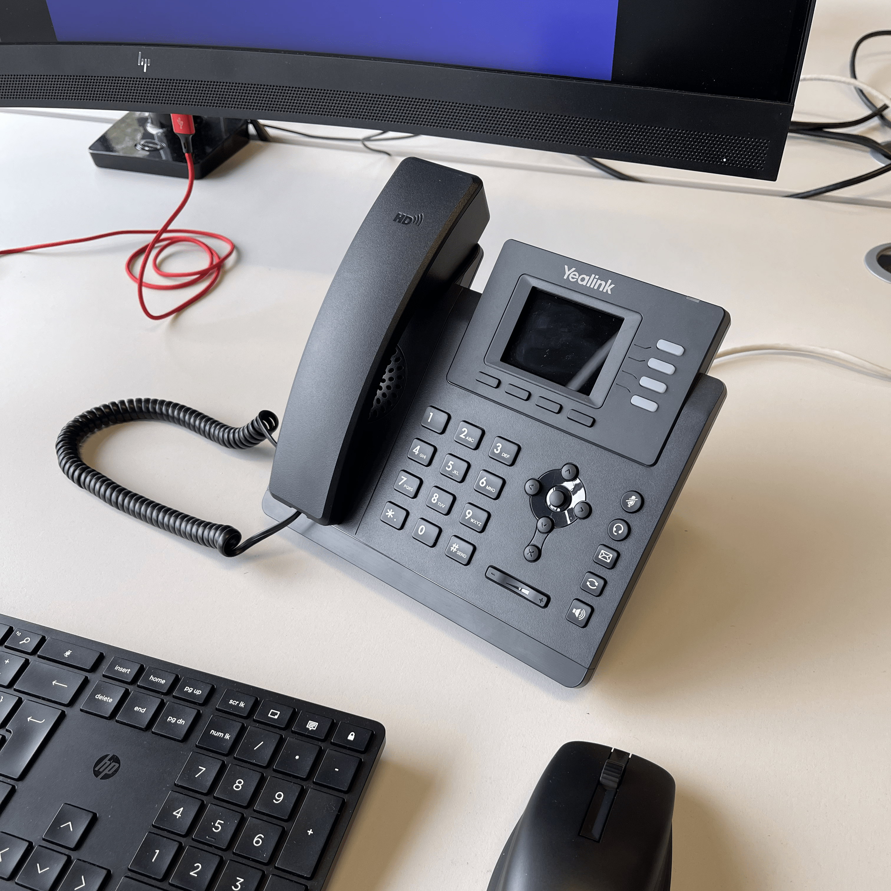 A Yealink telephone on a desk.