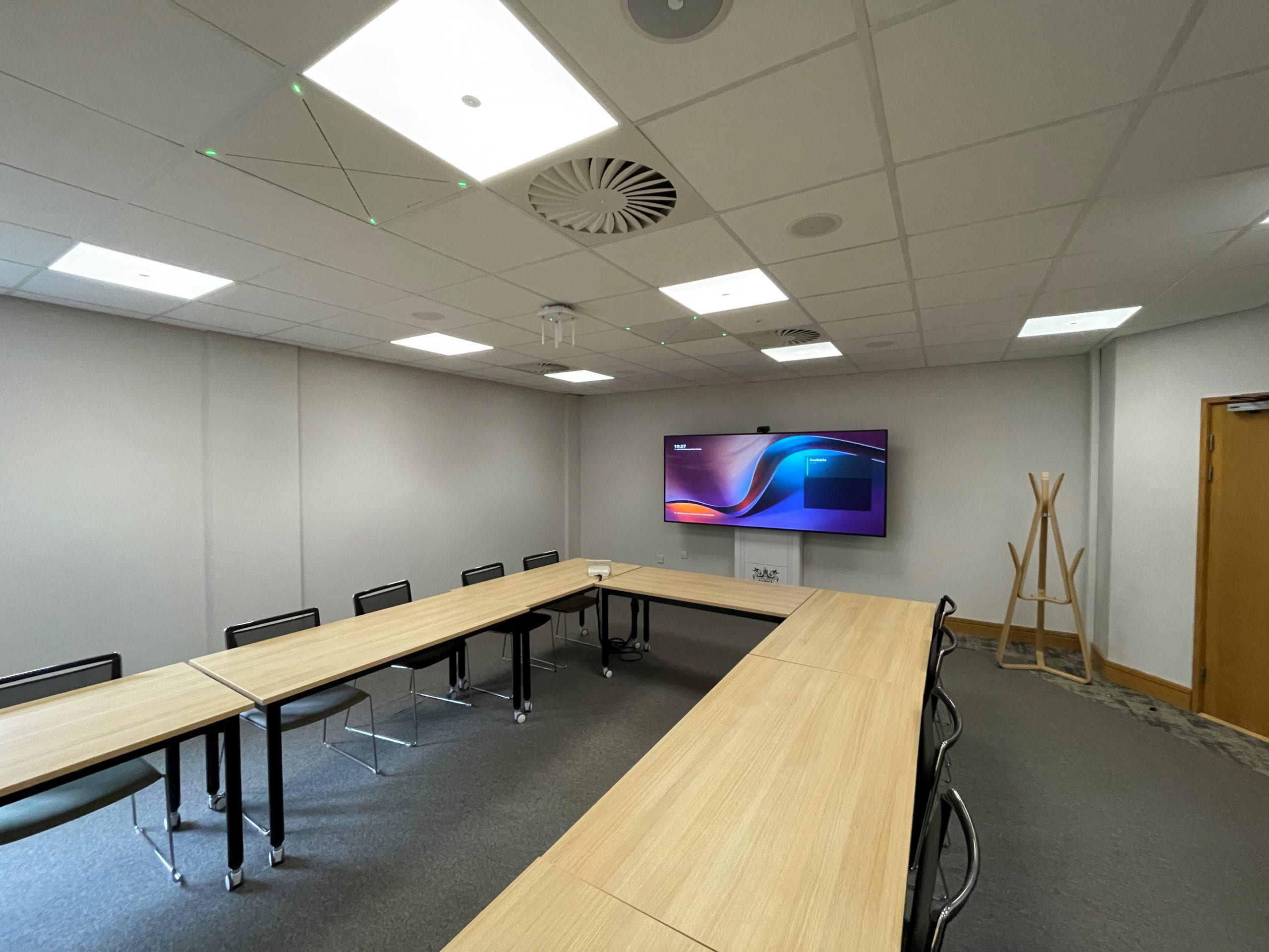 A photo of an upgraded meeting space in Lawress Hall with widescreen monitor and built in microphones in the ceiling.